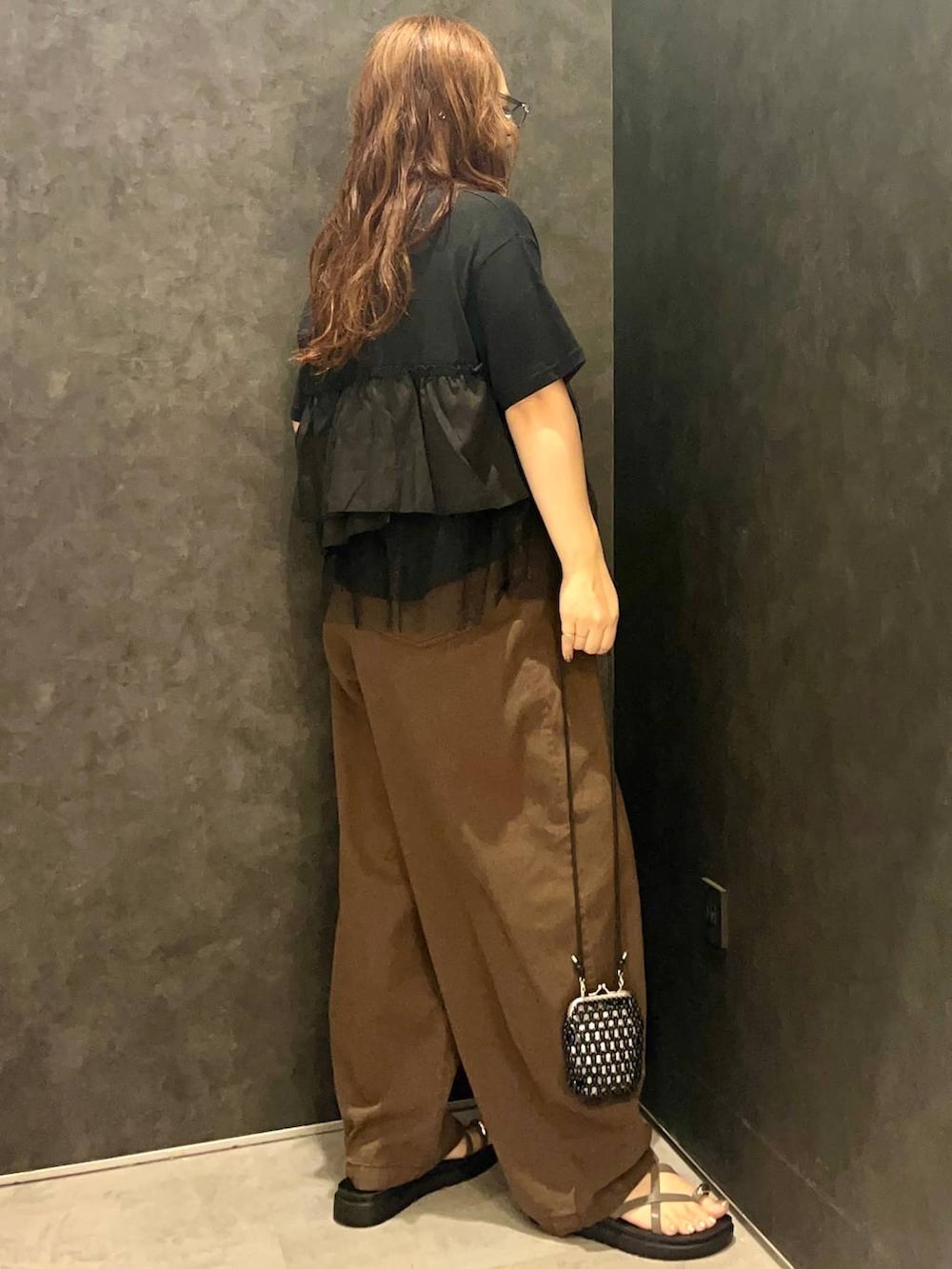 ブラウン系のその他パンツ、ブラウン系のサンダル、ブラック系のTシャツ/カットソーを着用したレディースの夏コーディネートの2枚目の写真