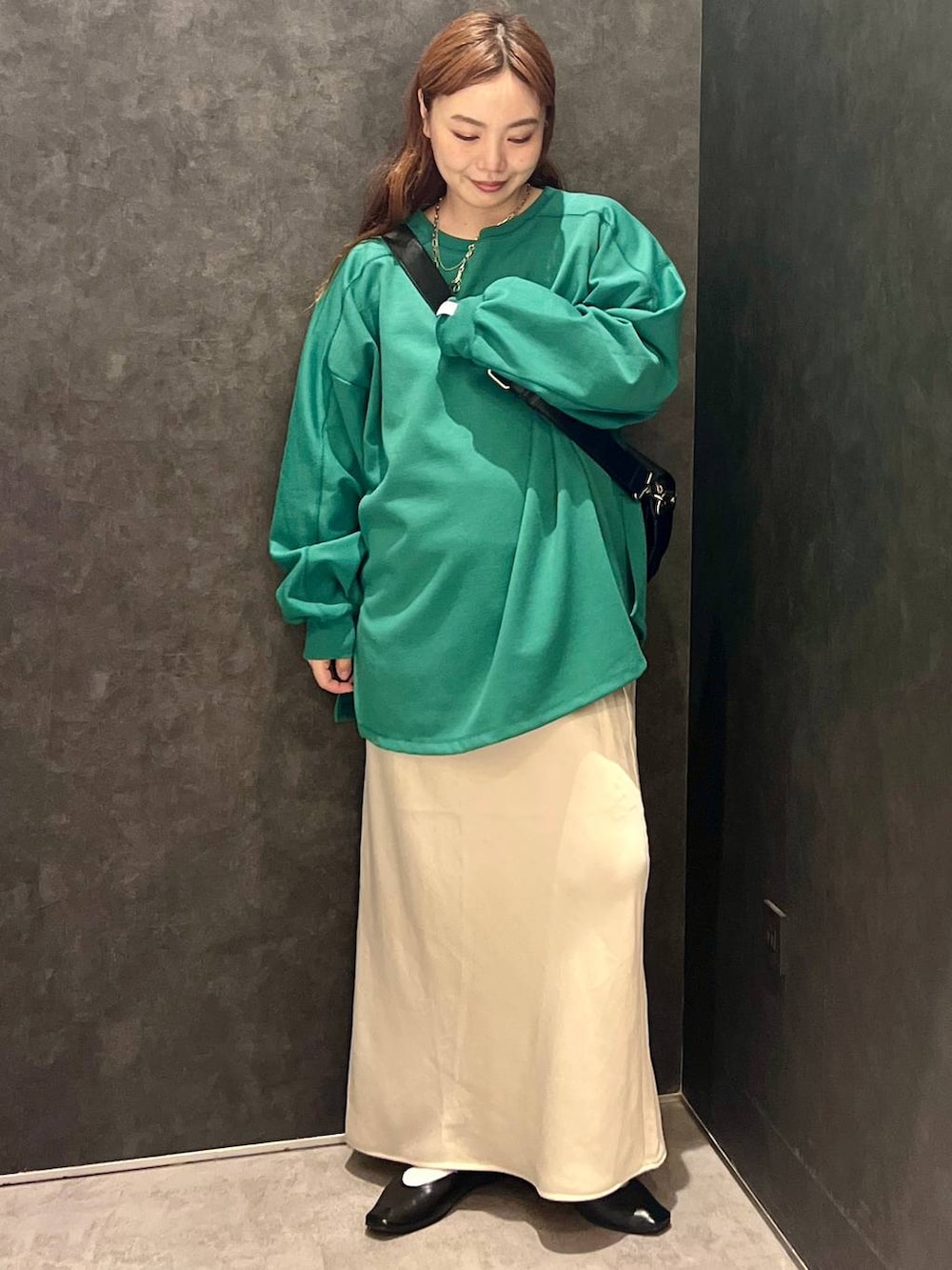 ホワイト系のスカート、グリーン系のTシャツ/カットソー、ブラック系のショルダーバッグを着用したレディースの秋コーディネートの5枚目の写真