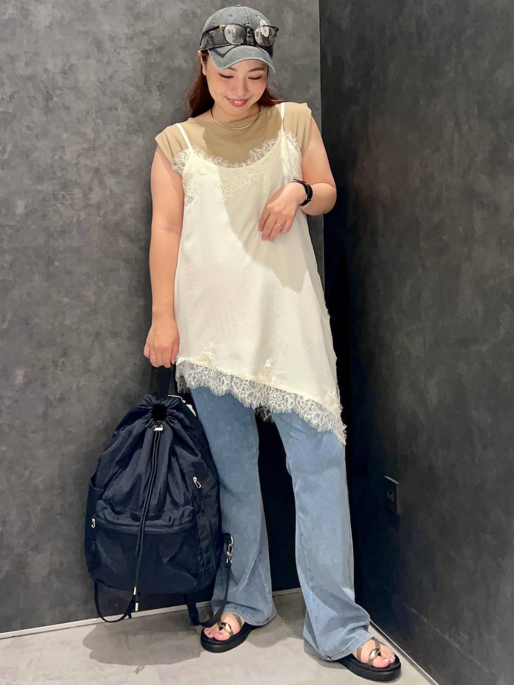 ベージュ系のTシャツ/カットソー、ブラウン系のサンダル、ブラック系のバックパック/リュックを着用したレディースの夏コーディネートの4枚目の写真