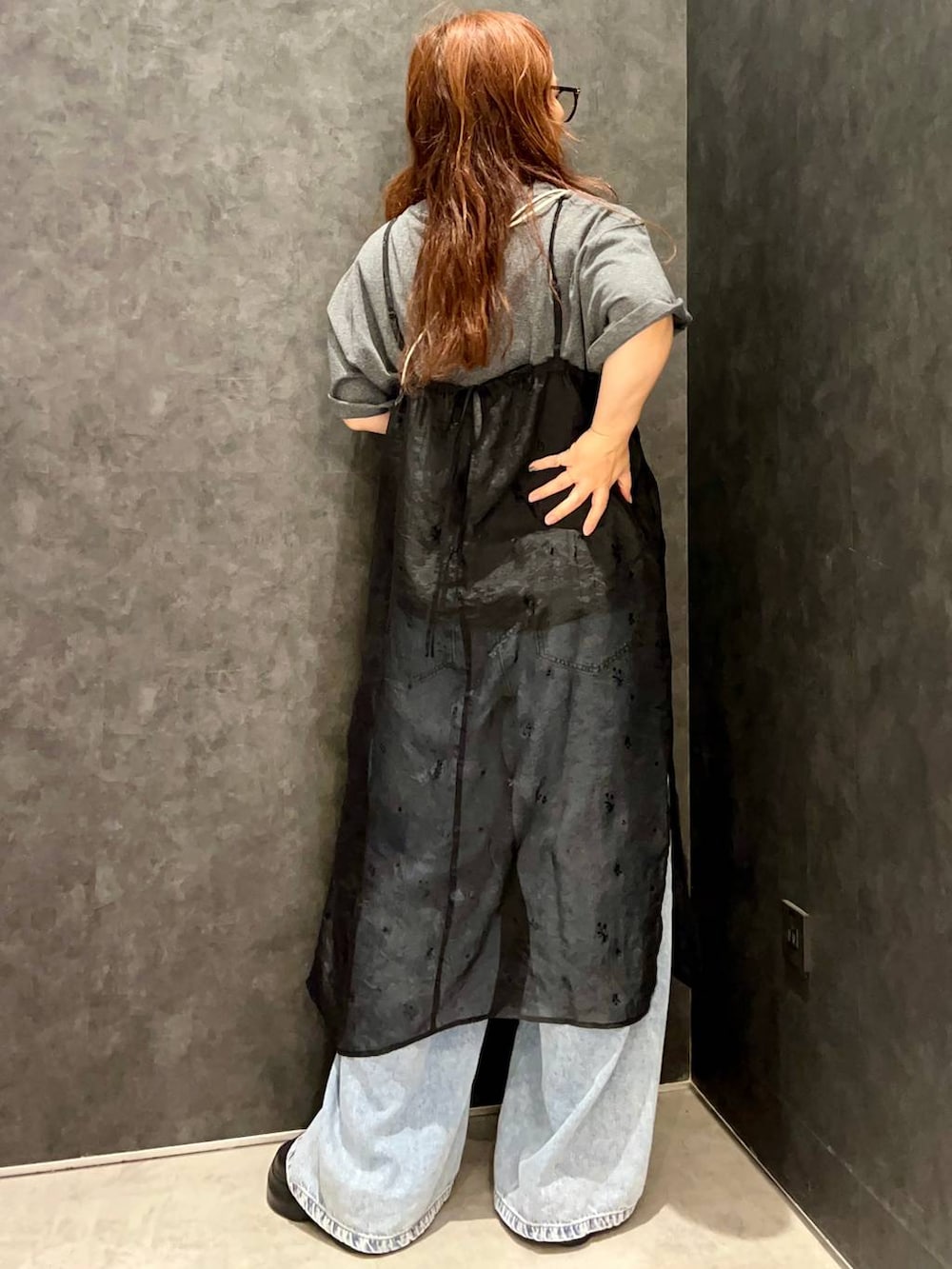 ブラック系のワンピース、グレー系のTシャツ/カットソー、ブルー系のデニムパンツを着用したレディースの夏コーディネートの3枚目の写真