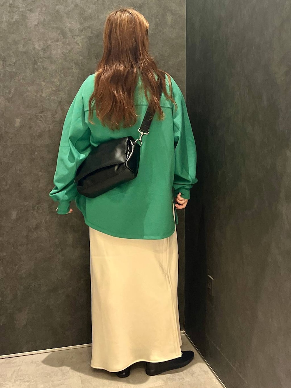 ホワイト系のスカート、グリーン系のTシャツ/カットソー、ブラック系のショルダーバッグを着用したレディースの秋コーディネートの3枚目の写真