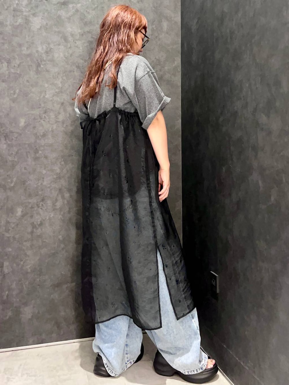ブラック系のワンピース、グレー系のTシャツ/カットソー、ブルー系のデニムパンツを着用したレディースの夏コーディネートの2枚目の写真