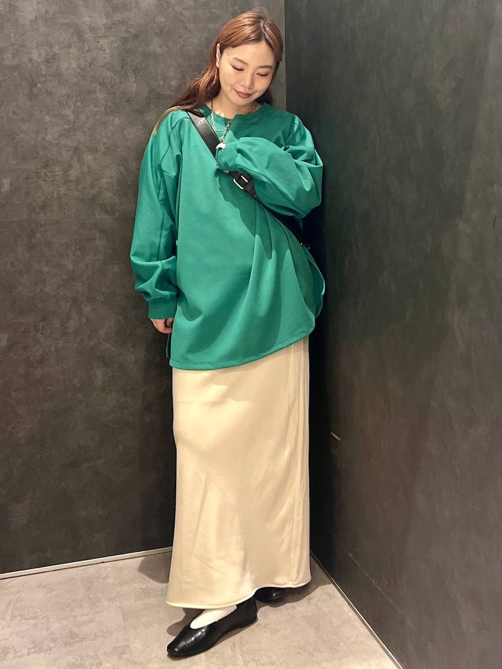 ホワイト系のスカート、グリーン系のTシャツ/カットソー、ブラック系のショルダーバッグを着用したレディースの秋コーディネートの2枚目の写真