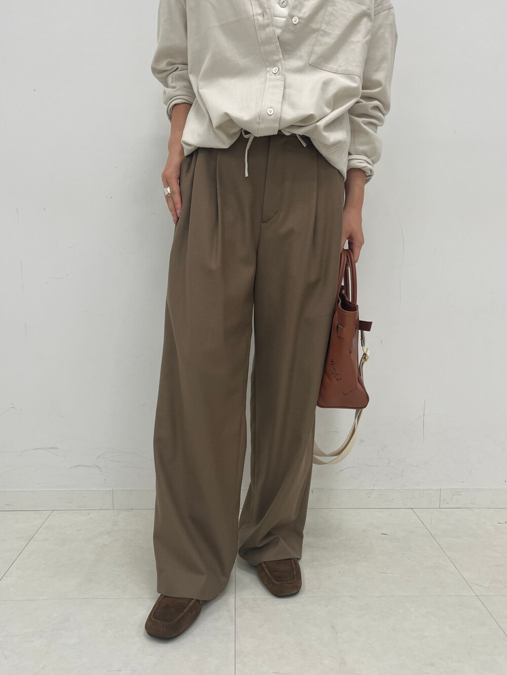ブラウン系のスラックス、ホワイト系のシャツ/ブラウス、ホワイト系のTシャツ/カットソーを着用したレディースの夏コーディネートの5枚目の写真