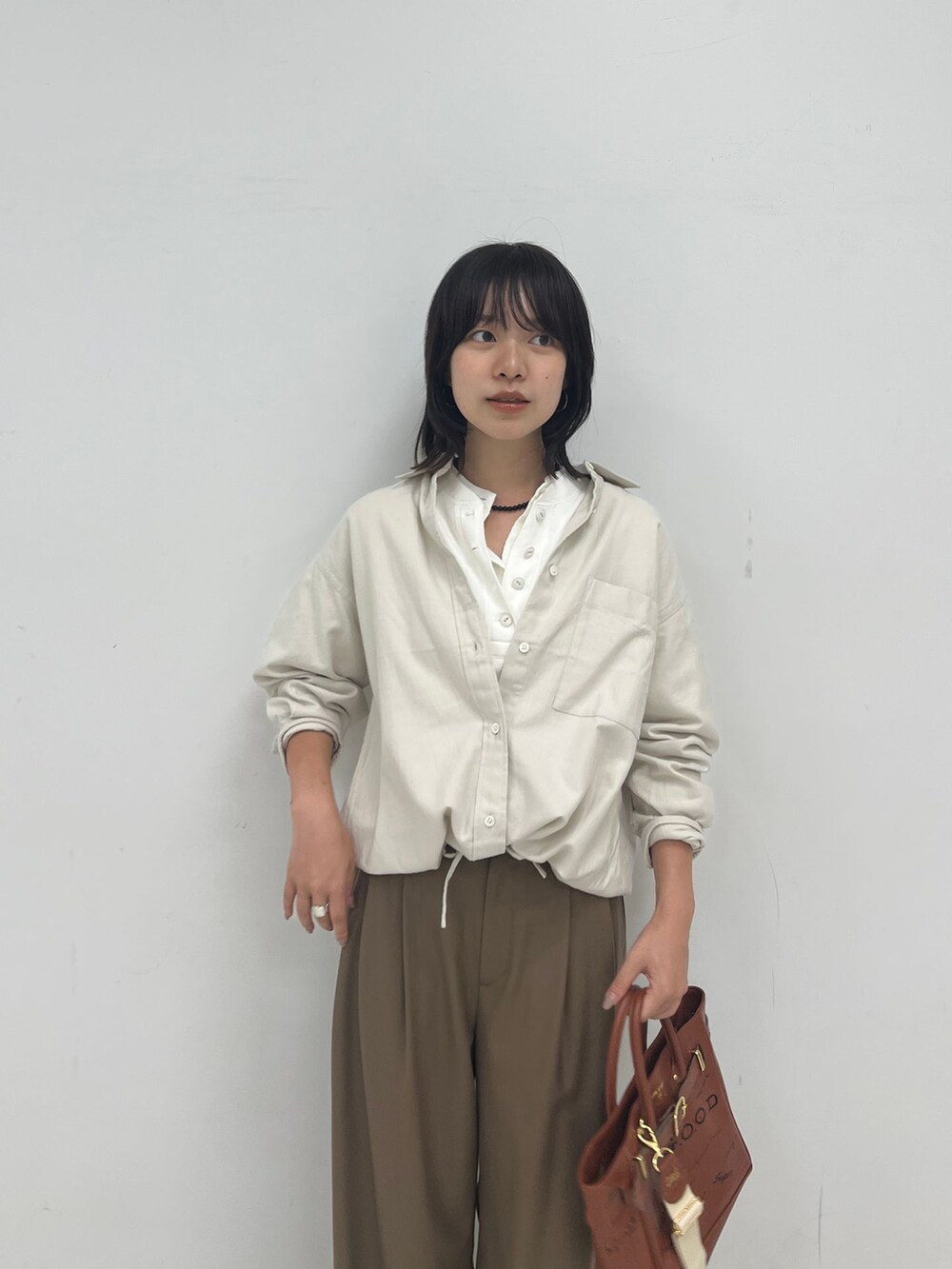 ブラウン系のスラックス、ホワイト系のシャツ/ブラウス、ホワイト系のTシャツ/カットソーを着用したレディースの夏コーディネートの4枚目の写真