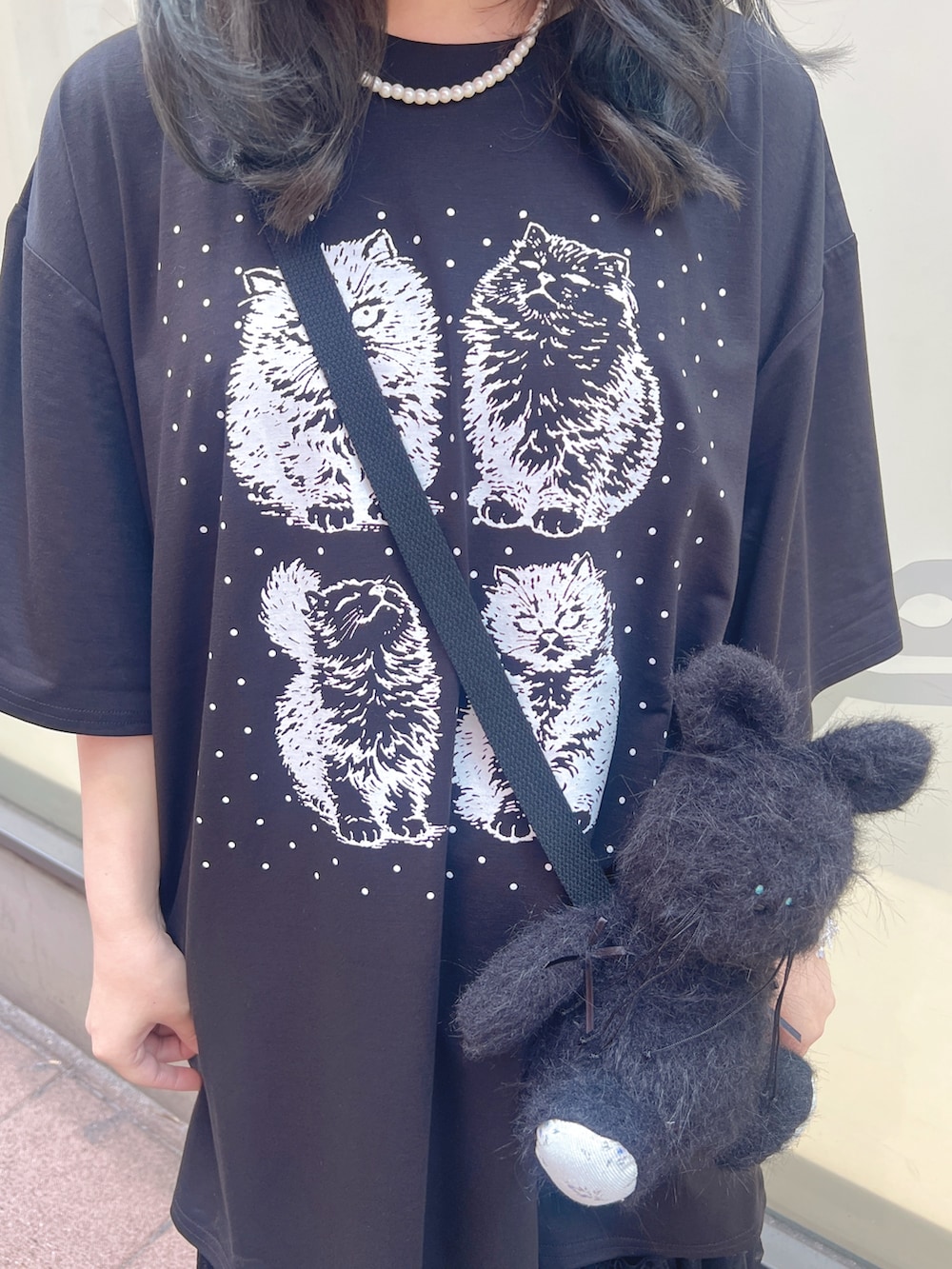 ブラック系のTシャツ/カットソー、ブラック系のショルダーバッグ、ブラック系のスカートを着用したレディースの春コーディネートの6枚目の写真