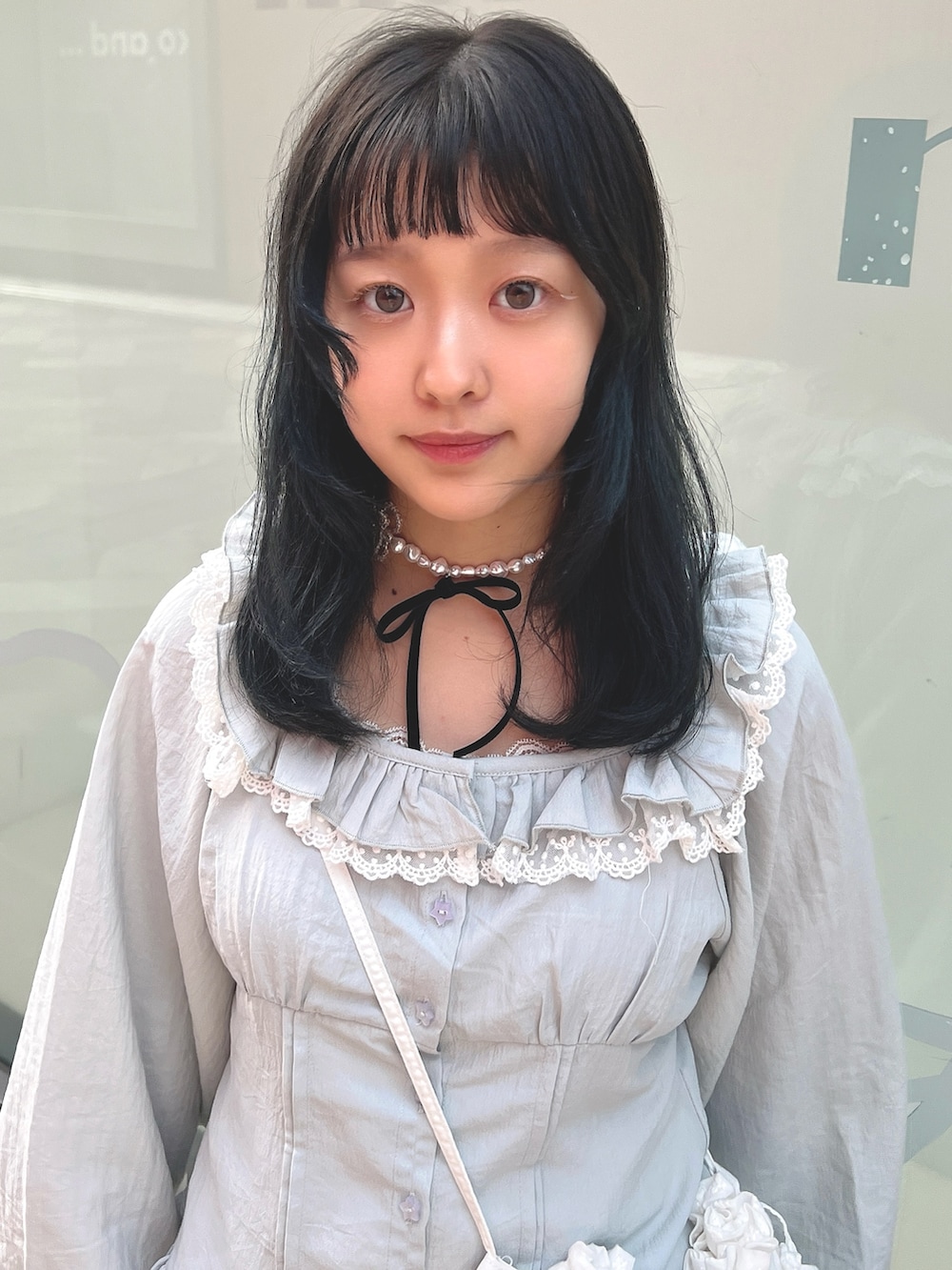 ホワイト系のショルダーバッグ、ブルー系のシャツ/ブラウス、ホワイト系のスカートを着用したレディースの春コーディネートの6枚目の写真