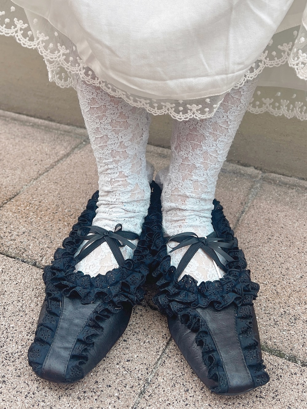 ブルー系のショルダーバッグ、ブラック系のバレエシューズ、ホワイト系のワンピースを着用したレディースの冬コーディネートの9枚目の写真