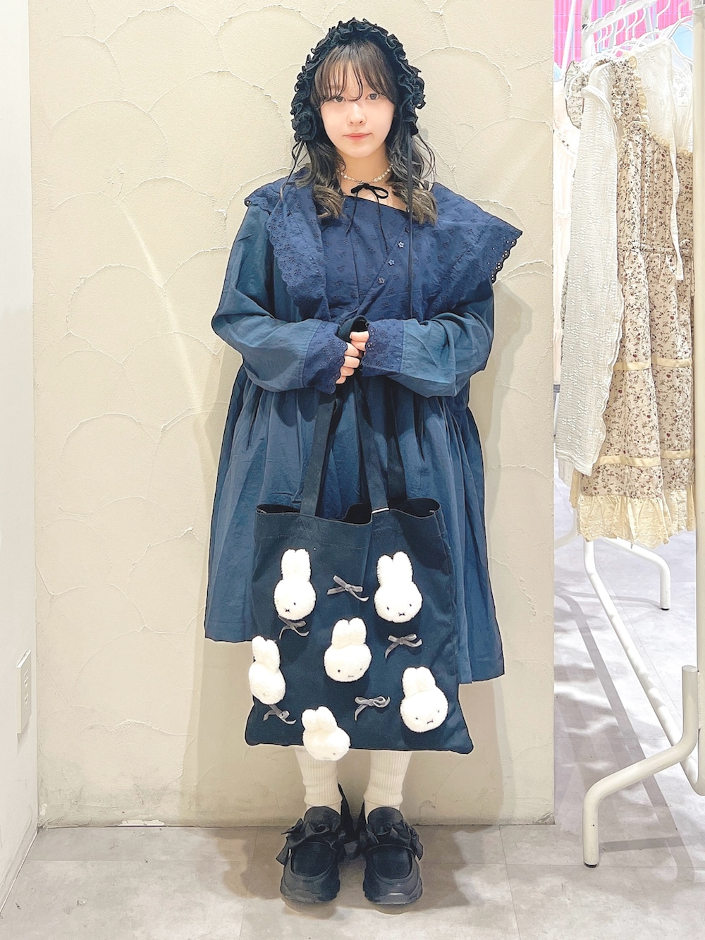 ブルー系のワンピース、ブラック系のトートバッグ、ブラック系のスニーカーを着用したレディースの春コーディネートの2枚目の写真