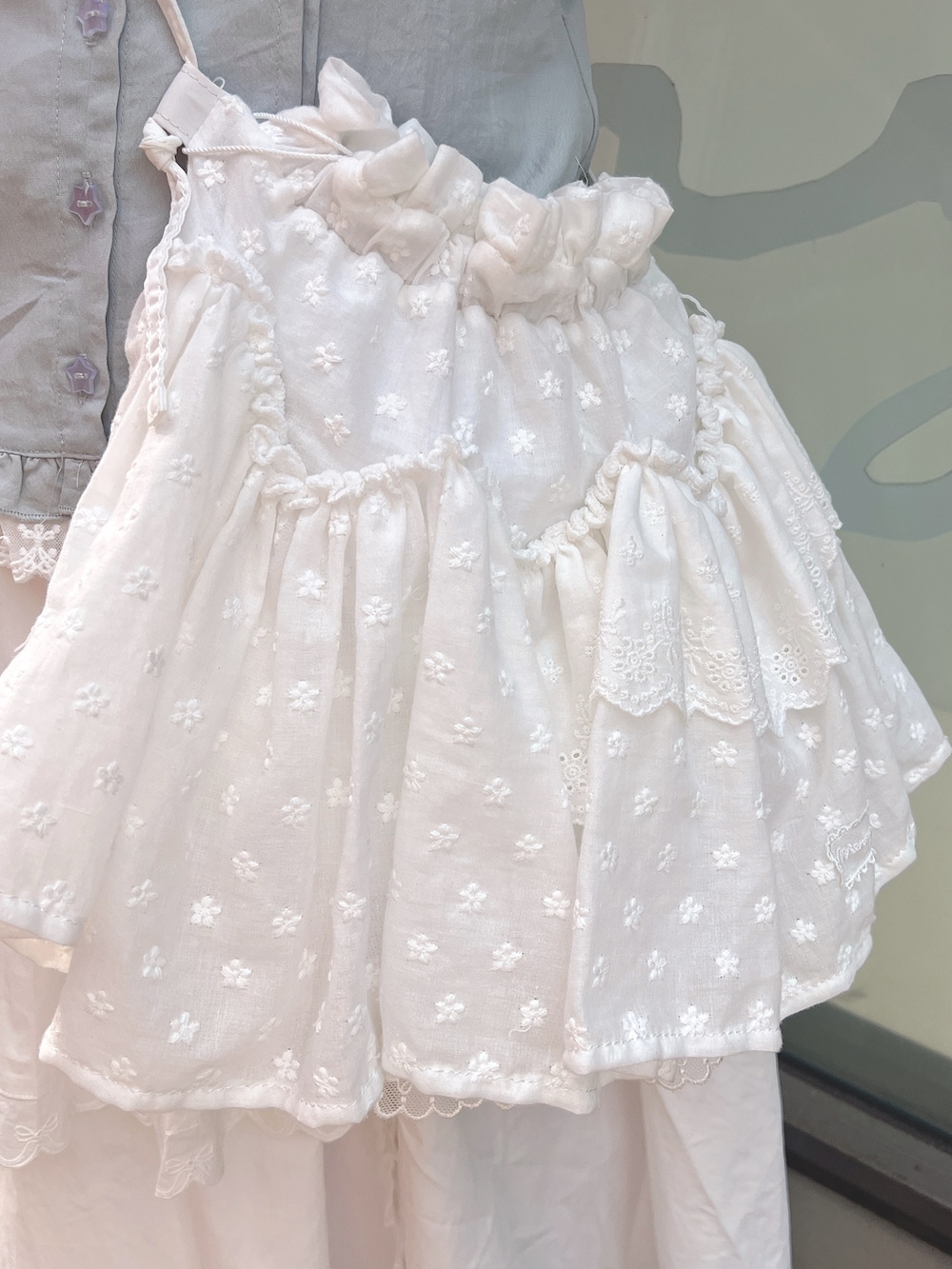 ホワイト系のショルダーバッグ、ブルー系のシャツ/ブラウス、ホワイト系のスカートを着用したレディースの春コーディネートの9枚目の写真