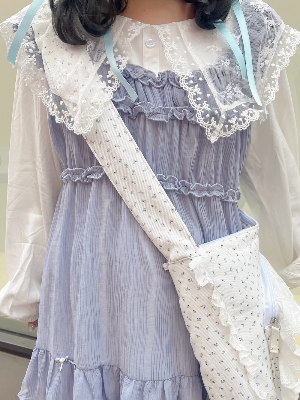 ブルー系のショルダーバッグ、ブラック系のバレエシューズ、ホワイト系のワンピースを着用したレディースの冬コーディネートの7枚目の写真