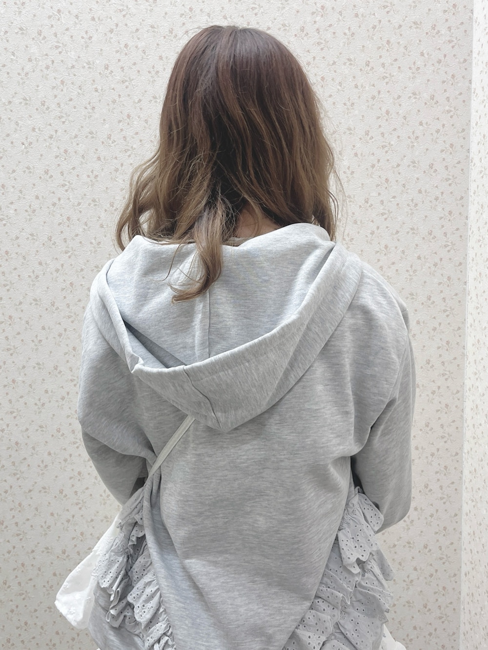 グレー系のパーカー、ブルー系のワンピース、ホワイト系のショルダーバッグを着用したレディースの冬コーディネートの6枚目の写真