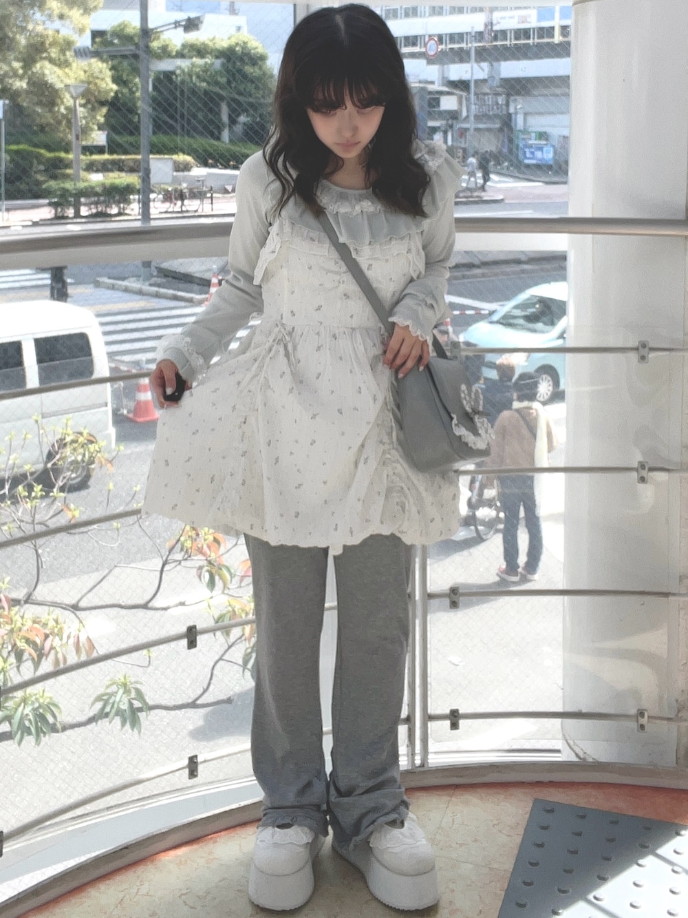 グリーン系のTシャツ/カットソー、ホワイト系のワンピース、ブルー系のショルダーバッグを着用したレディースの春コーディネートの2枚目の写真