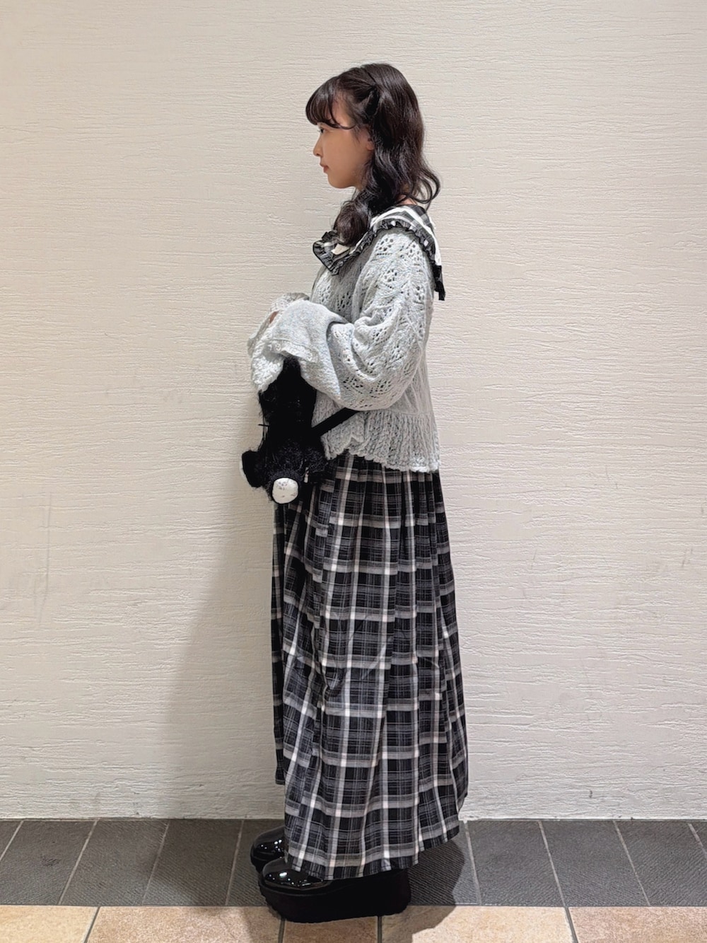 ブルー系のカーディガン/ボレロ、ブラック系のワンピース、ブラック系のショルダーバッグを着用したレディースの秋コーディネートの2枚目の写真