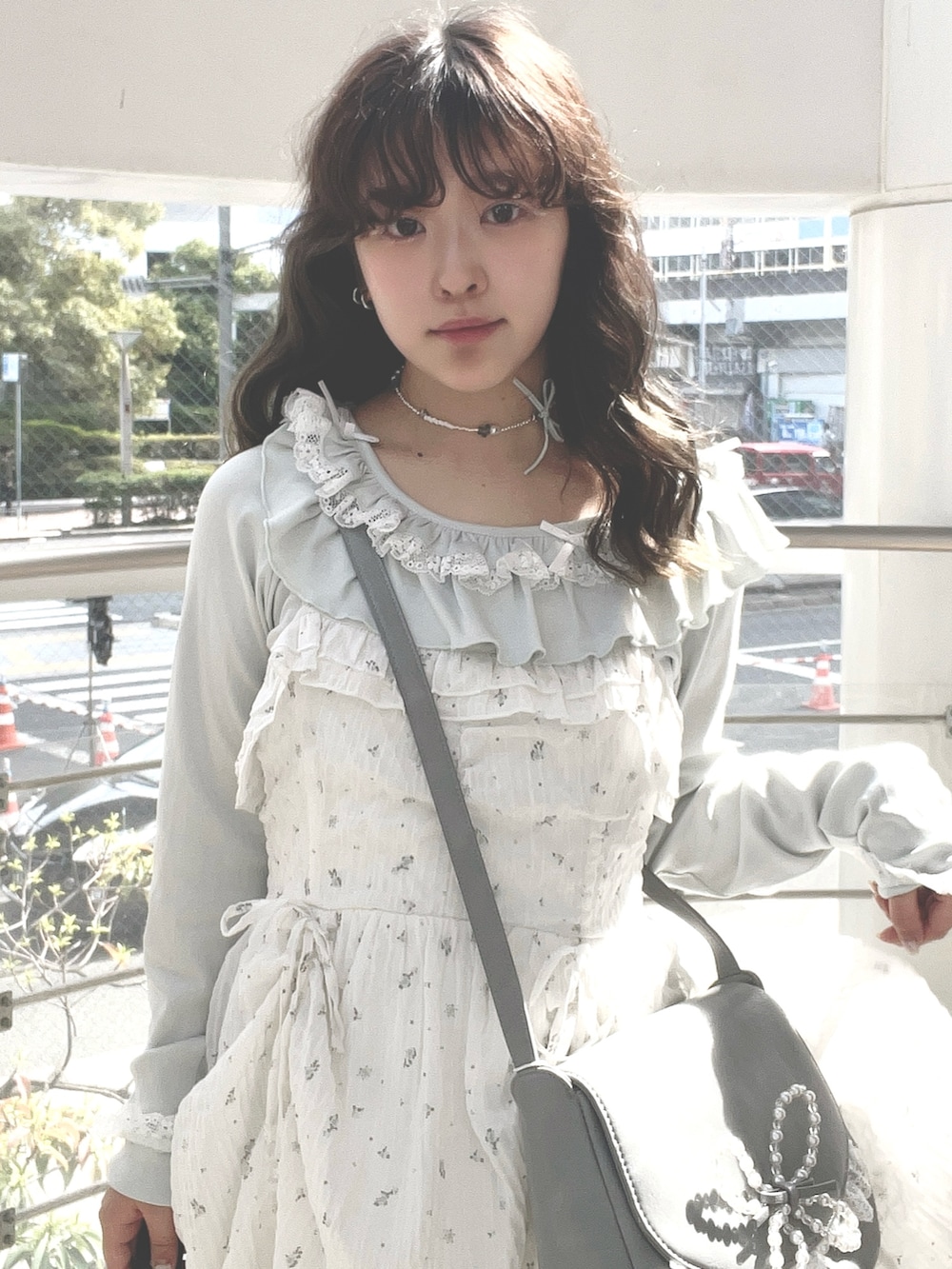 グリーン系のTシャツ/カットソー、ホワイト系のワンピース、ブルー系のショルダーバッグを着用したレディースの春コーディネートの4枚目の写真