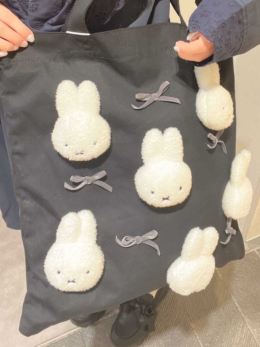 ブルー系のワンピース、ブラック系のトートバッグ、ブラック系のスニーカーを着用したレディースの春コーディネートの9枚目の写真