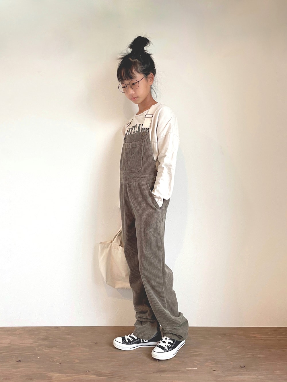 グリーン系のサロペット/オーバーオール、ベージュ系のTシャツ/カットソーを着用したキッズの秋コーディネートの2枚目の写真