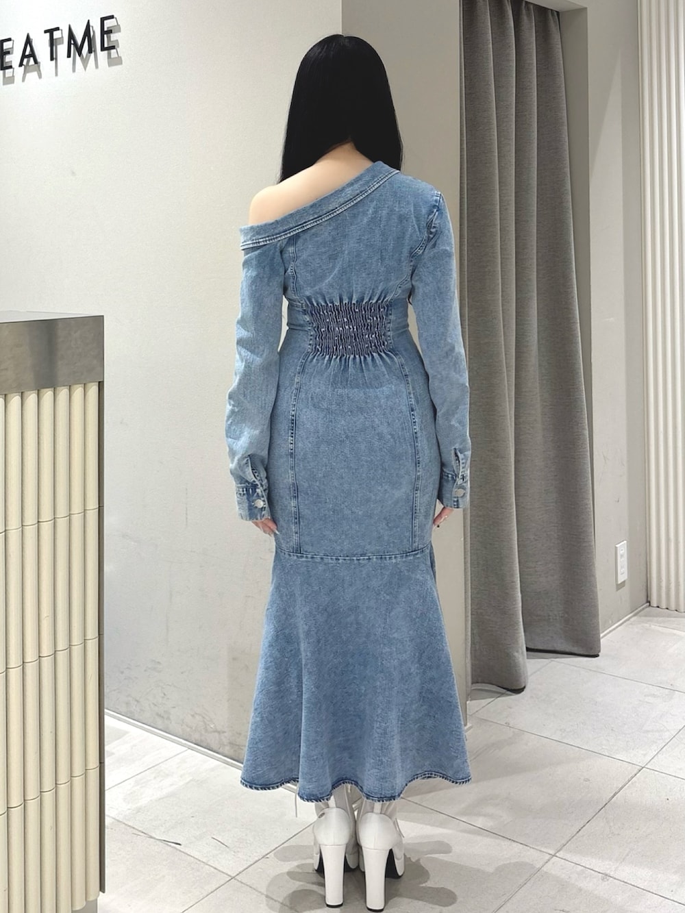 ブルー系のワンピース、ホワイト系のブーツを着用したレディースの冬コーディネートの3枚目の写真