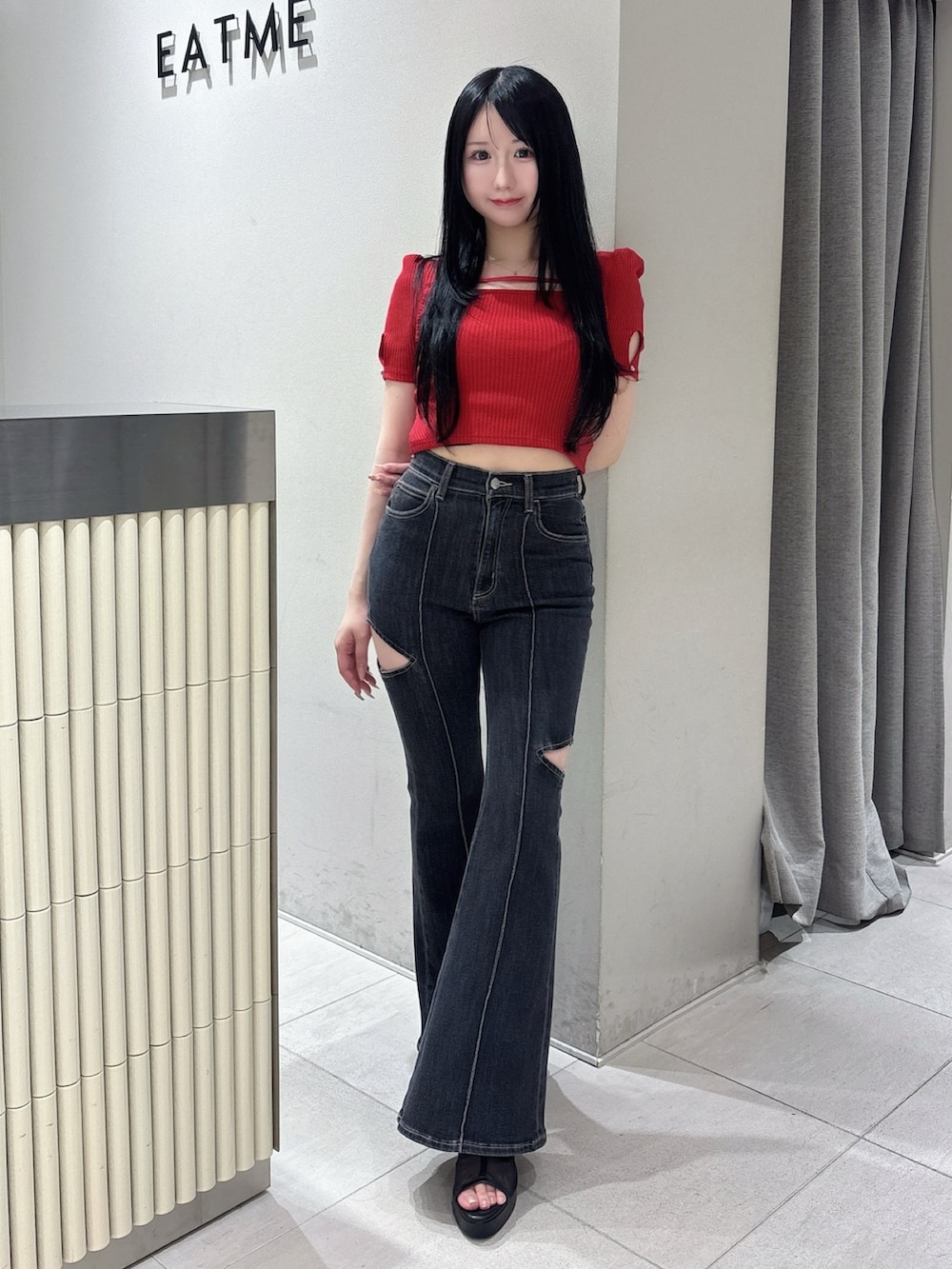 ブラック系のデニムパンツ、レッド系のTシャツ/カットソー、ブラック系のサンダルを着用したレディースの春コーディネートの2枚目の写真