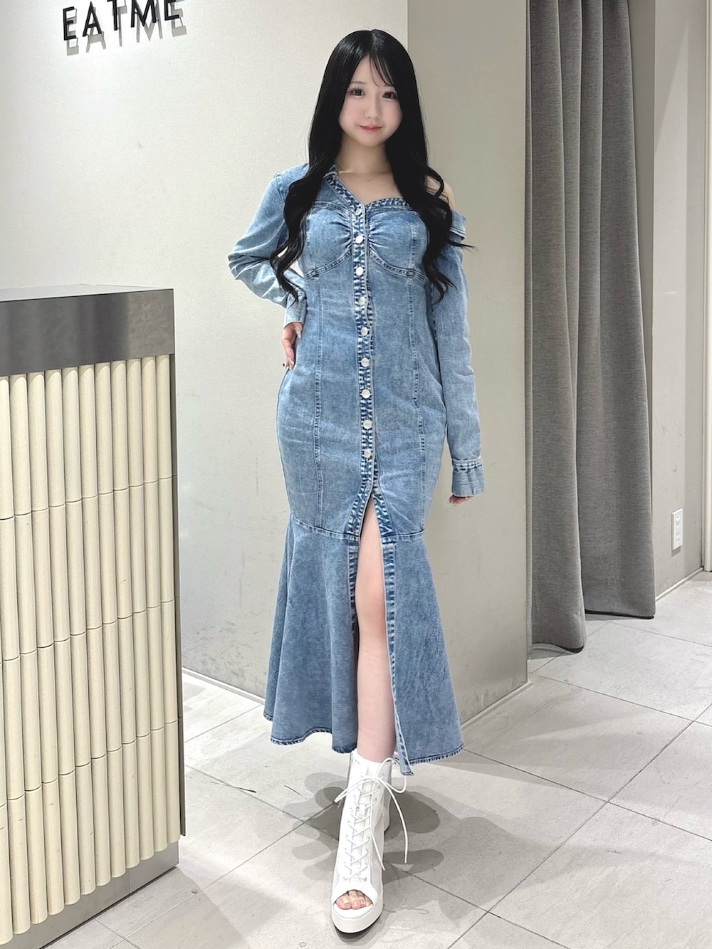 ブルー系のワンピース、ホワイト系のブーツを着用したレディースの冬コーディネートの2枚目の写真