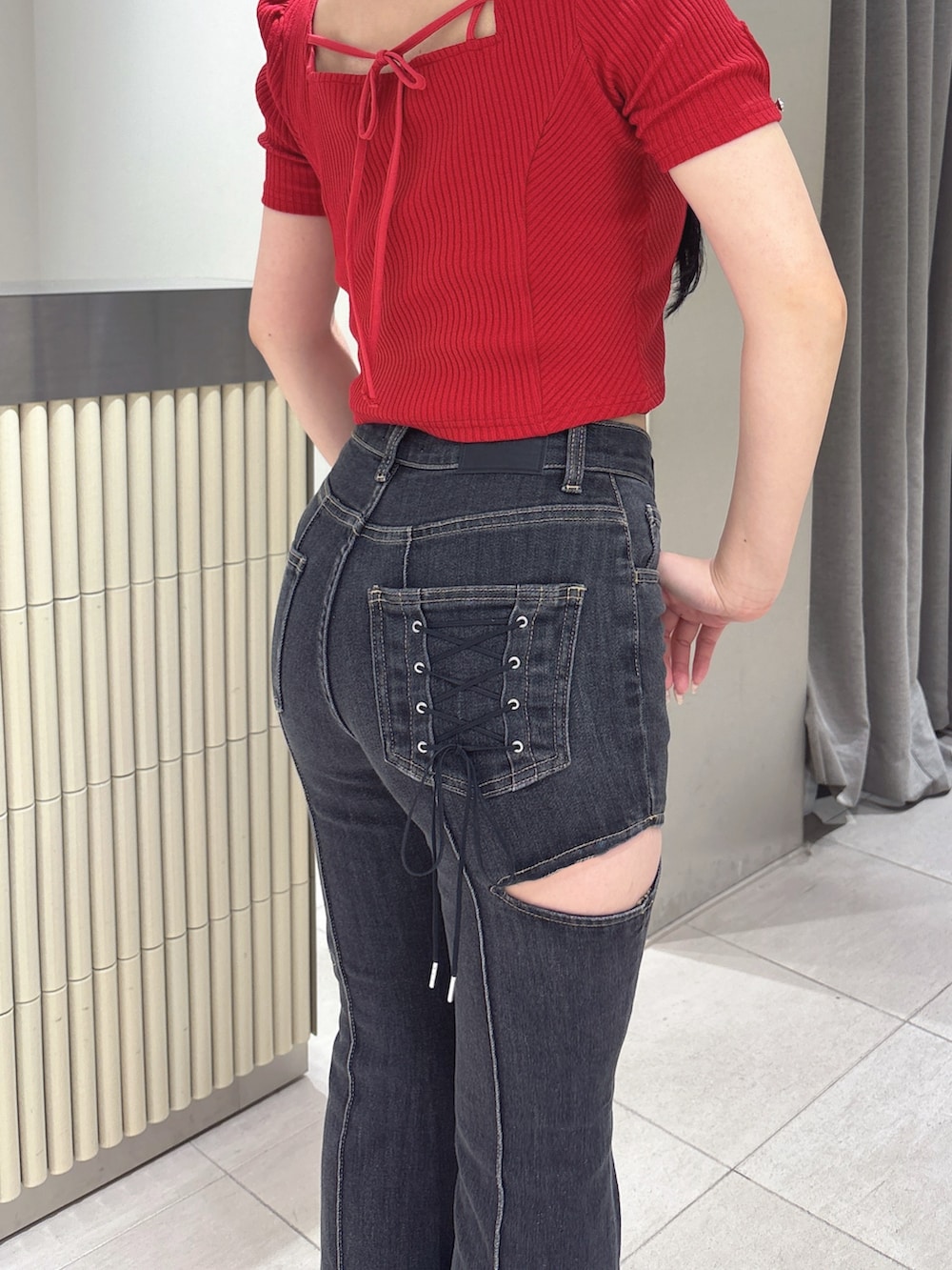 ブラック系のデニムパンツ、レッド系のTシャツ/カットソー、ブラック系のサンダルを着用したレディースの春コーディネートの5枚目の写真