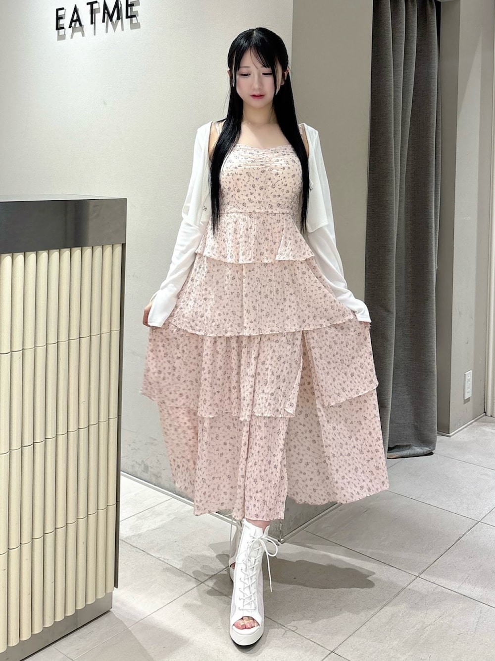 ピンク系のワンピース、ホワイト系のTシャツ/カットソー、ホワイト系のブーツを着用したレディースの春コーディネートの2枚目の写真