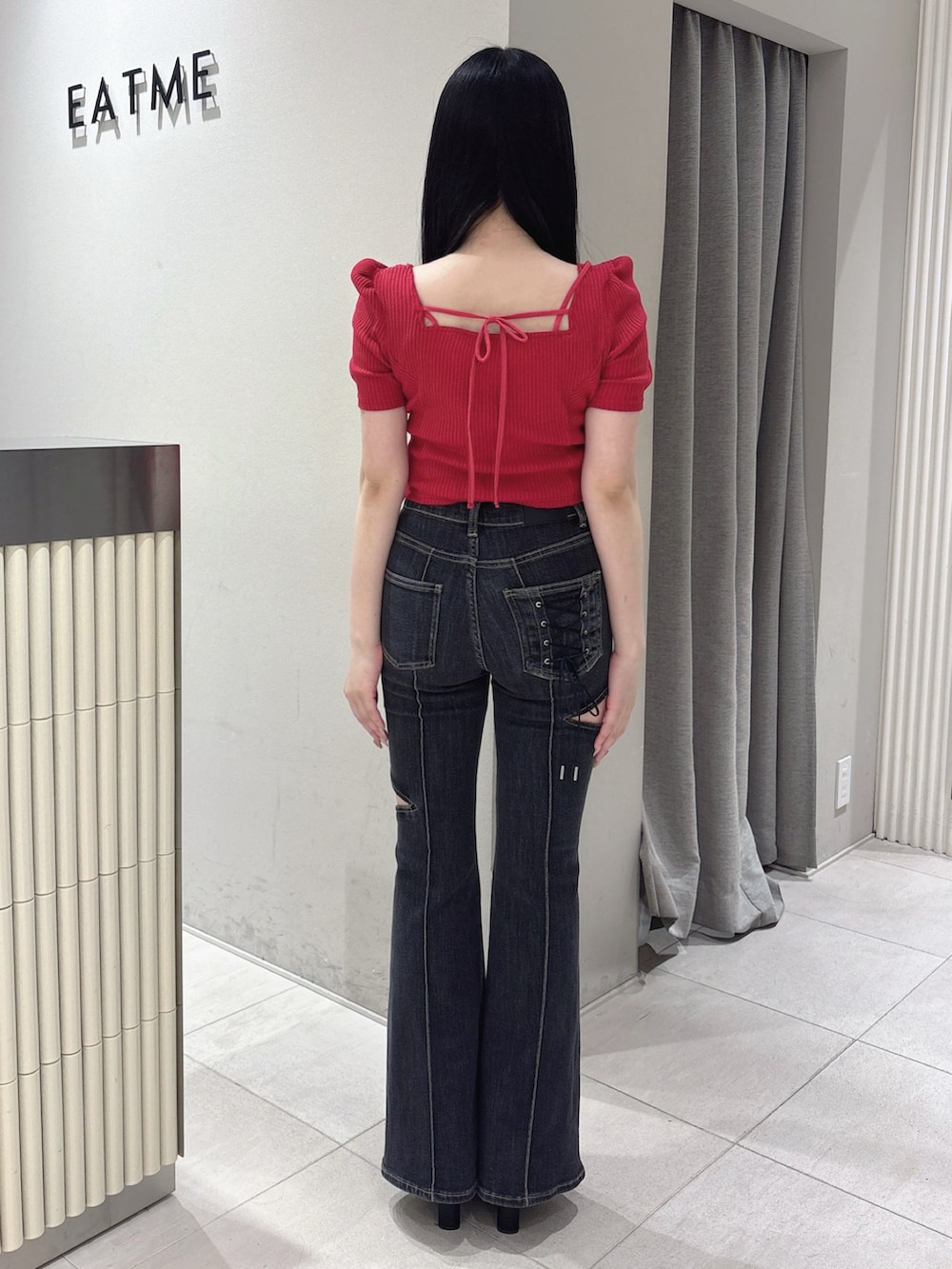 ブラック系のデニムパンツ、レッド系のTシャツ/カットソー、ブラック系のサンダルを着用したレディースの春コーディネートの4枚目の写真