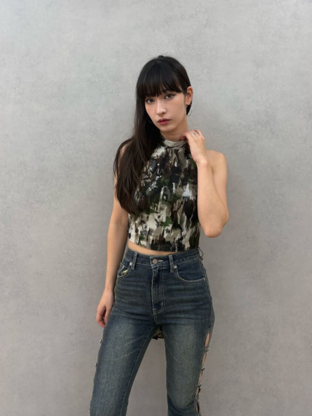 グリーン系のキャミソール、ブルー系のデニムパンツ、ブラック系のサンダルを着用したレディースの夏コーディネートの4枚目の写真
