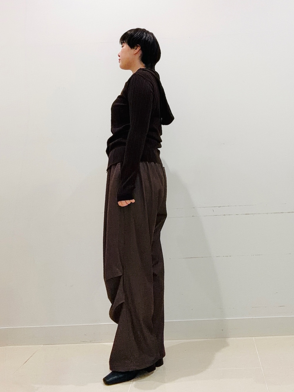 ブラウン系のニット/セーター、ブラウン系のその他パンツ、ブラック系のブーツを着用したレディースの秋コーディネートの2枚目の写真