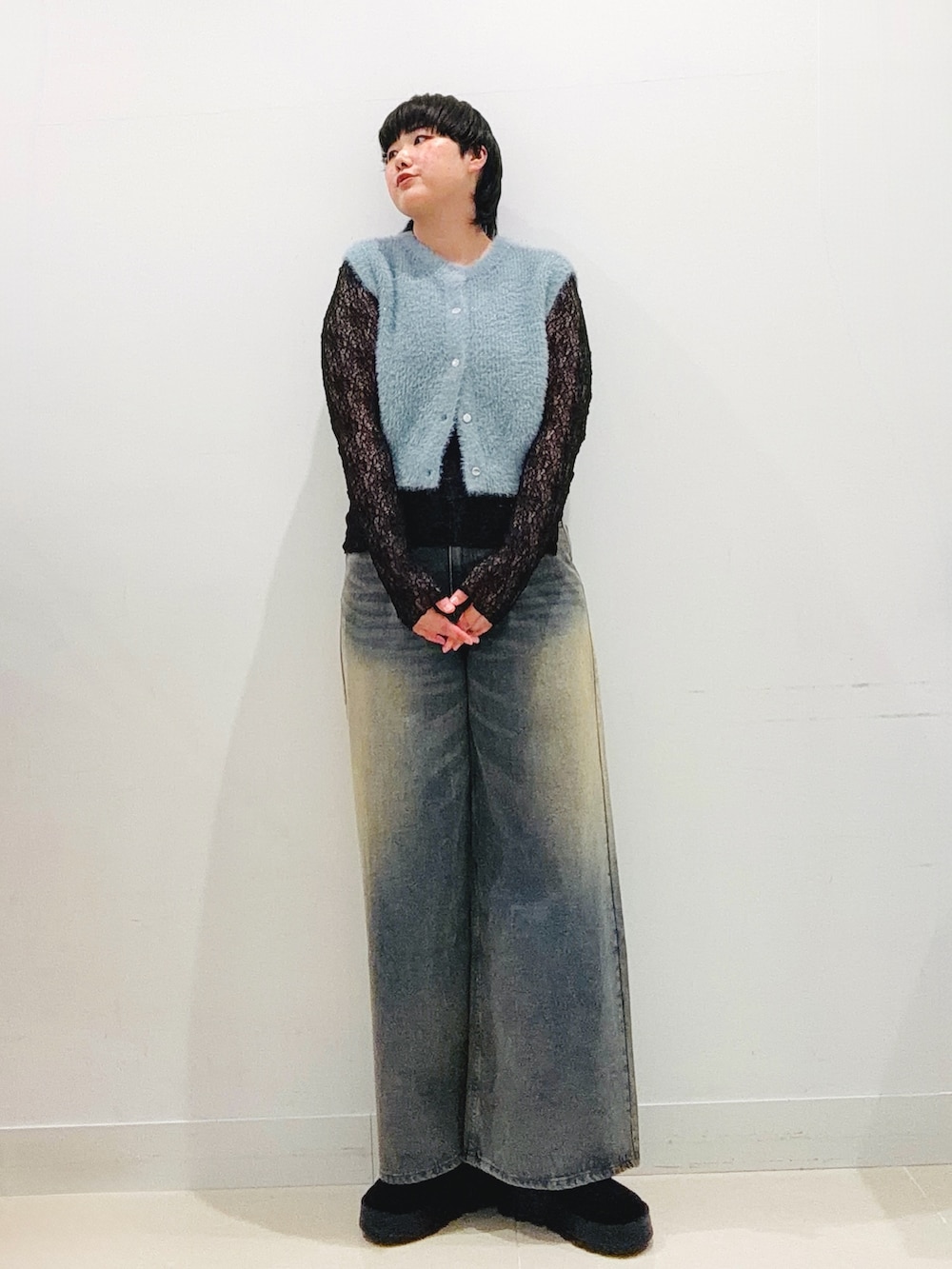 ブルー系のニット/セーター、ブラック系のTシャツ/カットソー、ブルー系のデニムパンツを着用したレディースの秋コーディネートの6枚目の写真