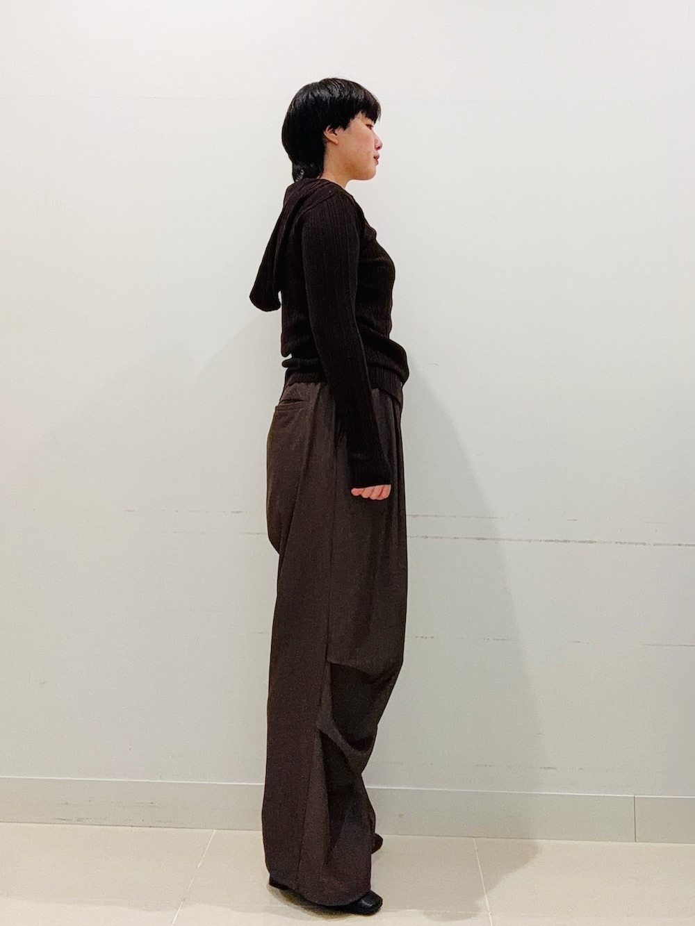 ブラウン系のニット/セーター、ブラウン系のその他パンツ、ブラック系のブーツを着用したレディースの秋コーディネートの4枚目の写真