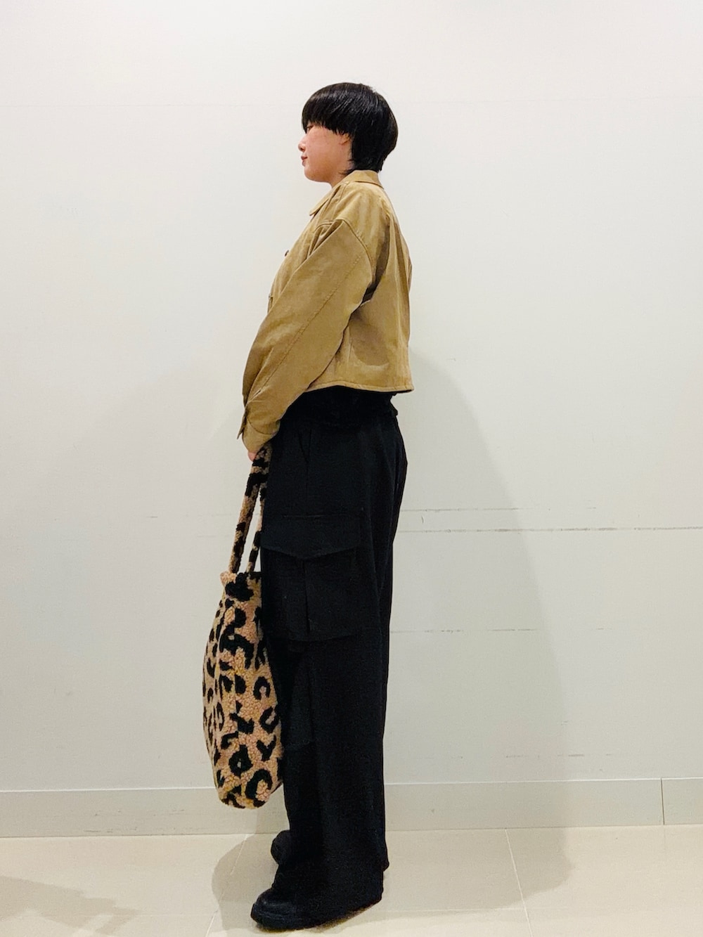 ブラック系のその他パンツ、ブラック系のブーツ、ベージュ系のその他アウターを着用したレディースの秋コーディネートの2枚目の写真