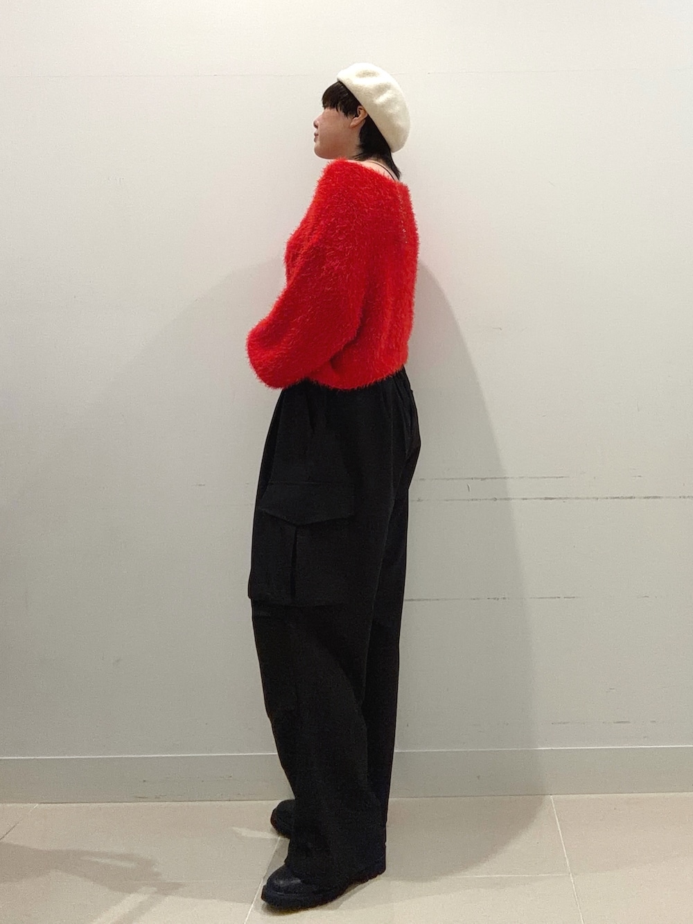 レッド系のニット/セーター、ブラック系のその他パンツ、ブラック系のブーツを着用したレディースの秋コーディネートの2枚目の写真