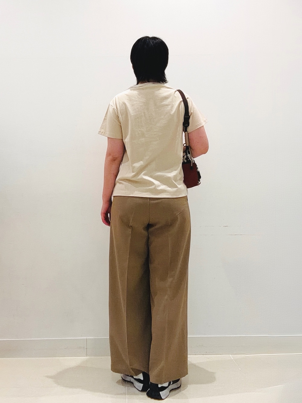ベージュ系のTシャツ/カットソー、ベージュ系のスラックス、その他のショルダーバッグを着用したレディースの夏コーディネートの3枚目の写真