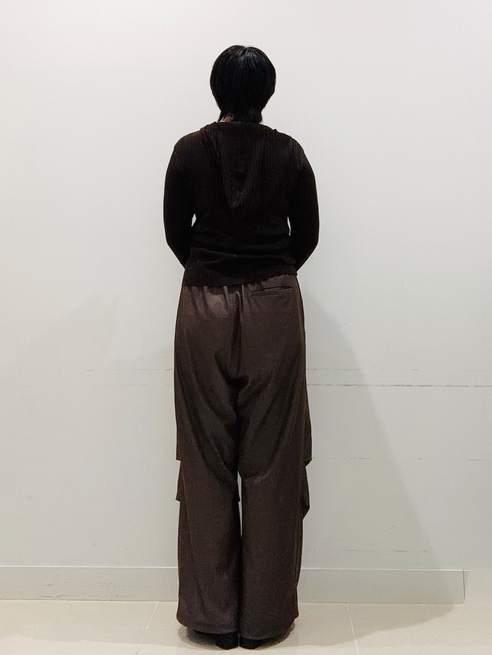 ブラウン系のニット/セーター、ブラウン系のその他パンツ、ブラック系のブーツを着用したレディースの秋コーディネートの3枚目の写真