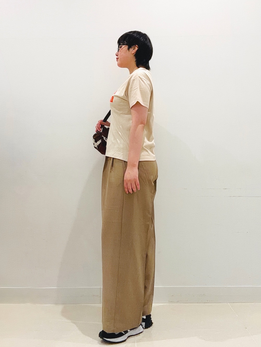 ベージュ系のTシャツ/カットソー、ベージュ系のスラックス、その他のショルダーバッグを着用したレディースの夏コーディネートの2枚目の写真