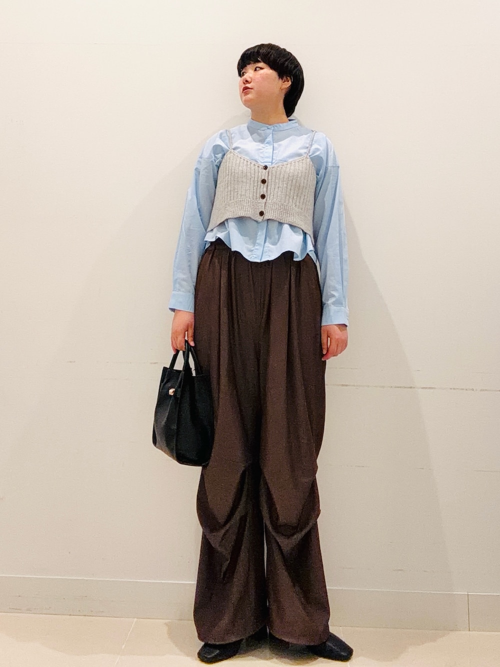 ブルー系のシャツ/ブラウス、ブラック系のハンドバッグ、ブラウン系のその他パンツを着用したレディースの秋コーディネートの5枚目の写真