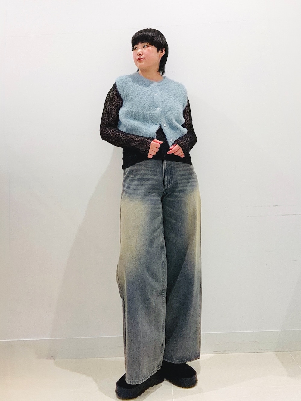 ブルー系のニット/セーター、ブラック系のTシャツ/カットソー、ブルー系のデニムパンツを着用したレディースの秋コーディネートの5枚目の写真