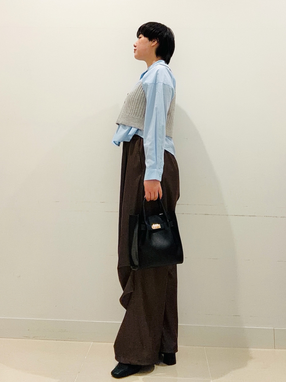 ブルー系のシャツ/ブラウス、ブラック系のハンドバッグ、ブラウン系のその他パンツを着用したレディースの秋コーディネートの2枚目の写真
