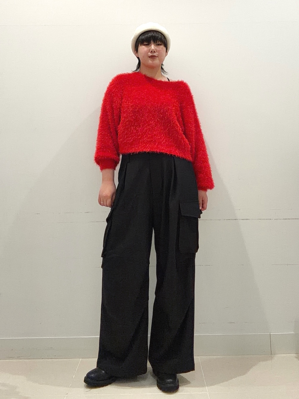 レッド系のニット/セーター、ブラック系のその他パンツ、ブラック系のブーツを着用したレディースの秋コーディネートの5枚目の写真