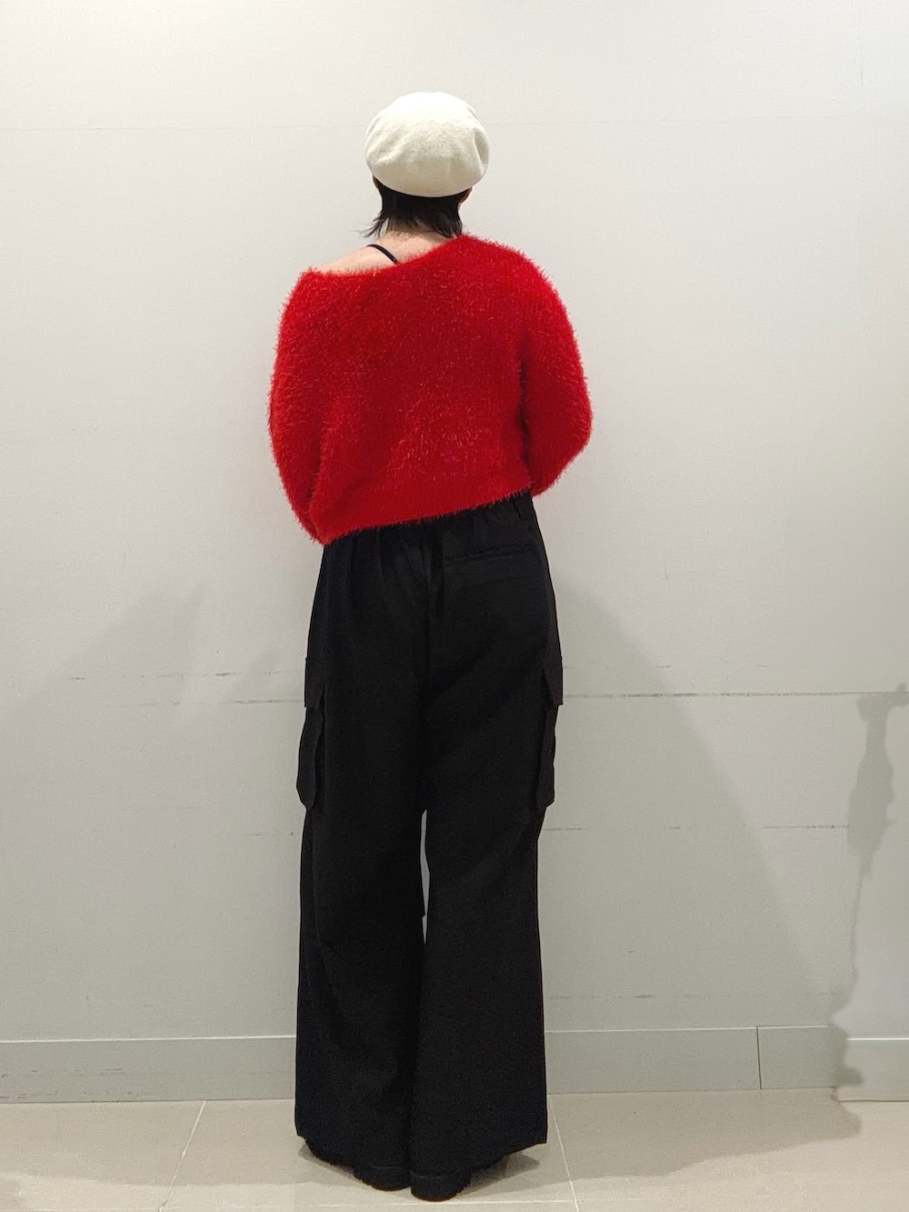 レッド系のニット/セーター、ブラック系のその他パンツ、ブラック系のブーツを着用したレディースの秋コーディネートの3枚目の写真