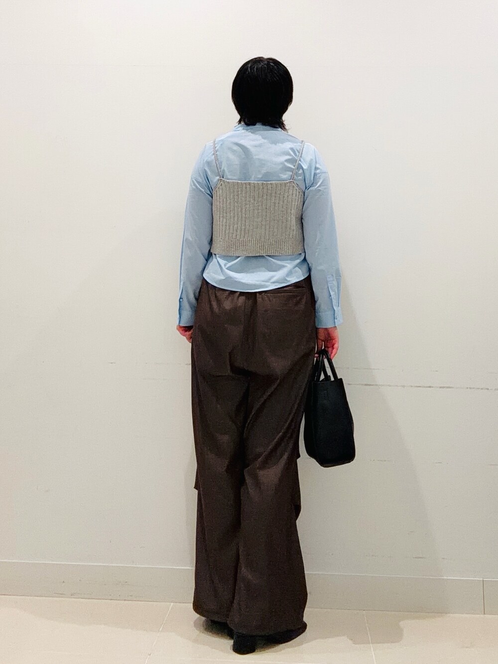 ブルー系のシャツ/ブラウス、ブラック系のハンドバッグ、ブラウン系のその他パンツを着用したレディースの秋コーディネートの3枚目の写真