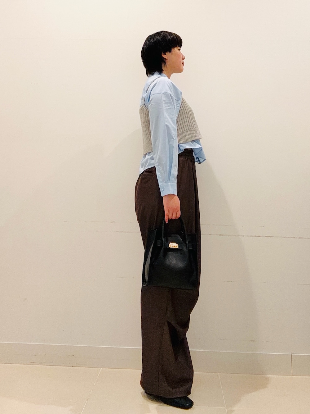 ブルー系のシャツ/ブラウス、ブラック系のハンドバッグ、ブラウン系のその他パンツを着用したレディースの秋コーディネートの4枚目の写真