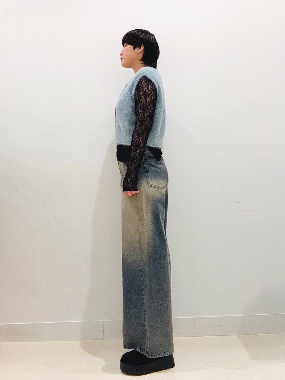 ブルー系のニット/セーター、ブラック系のTシャツ/カットソー、ブルー系のデニムパンツを着用したレディースの秋コーディネートの2枚目の写真