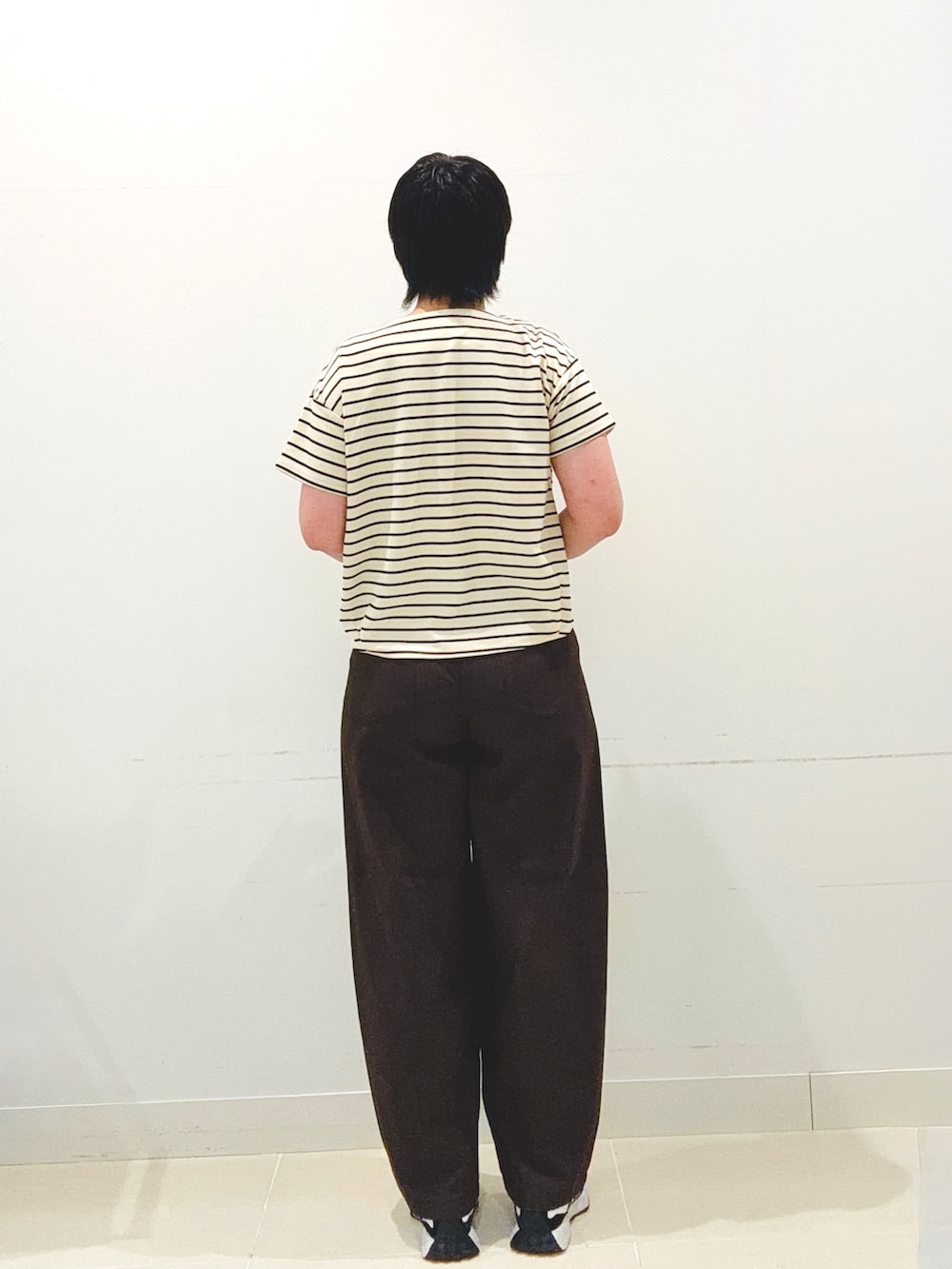 ホワイト系のキャミソール、ホワイト系のTシャツ/カットソー、ブラック系のハンドバッグを着用したレディースの夏コーディネートの3枚目の写真