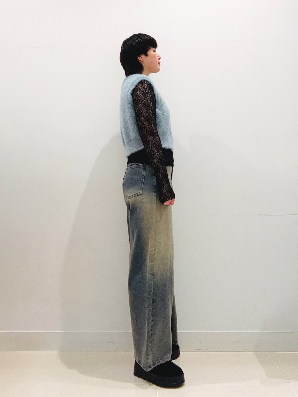 ブルー系のニット/セーター、ブラック系のTシャツ/カットソー、ブルー系のデニムパンツを着用したレディースの秋コーディネートの4枚目の写真