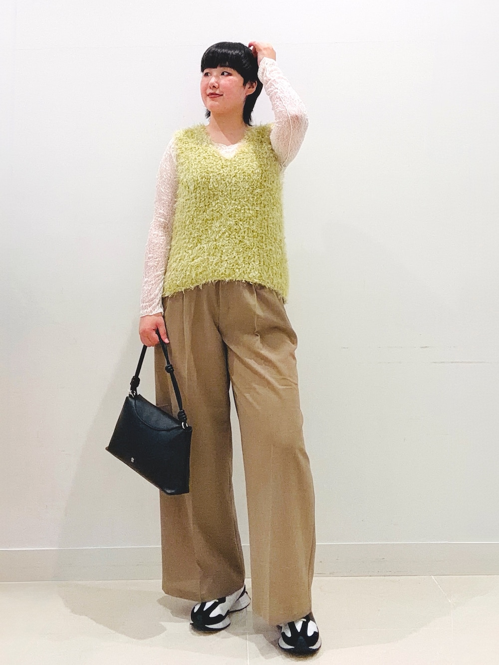 ベージュ系のスラックス、ベージュ系のベスト、ホワイト系のTシャツ/カットソーを着用したレディースの夏コーディネートの4枚目の写真