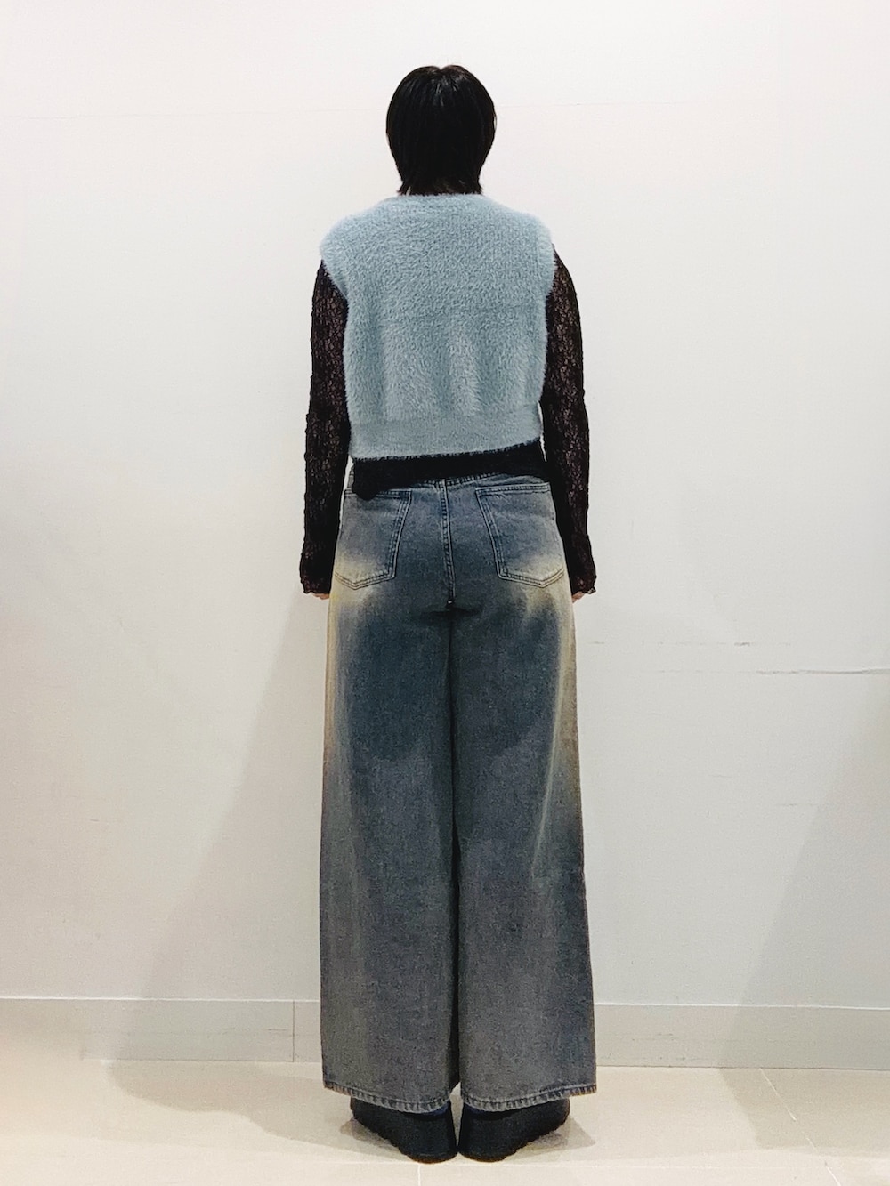 ブルー系のニット/セーター、ブラック系のTシャツ/カットソー、ブルー系のデニムパンツを着用したレディースの秋コーディネートの3枚目の写真
