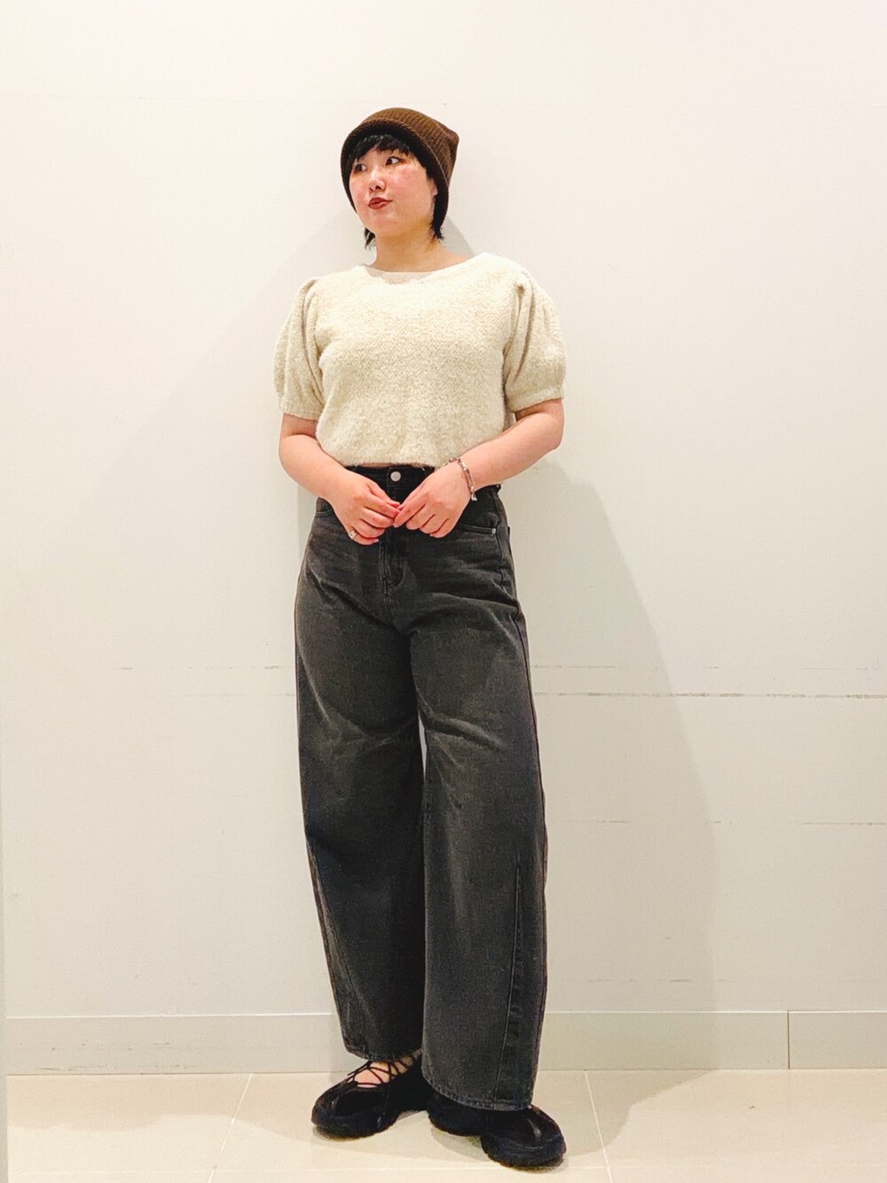 ブラウン系のスニーカー、ホワイト系のニット/セーター、グレー系のデニムパンツを着用したレディースの夏コーディネートの4枚目の写真