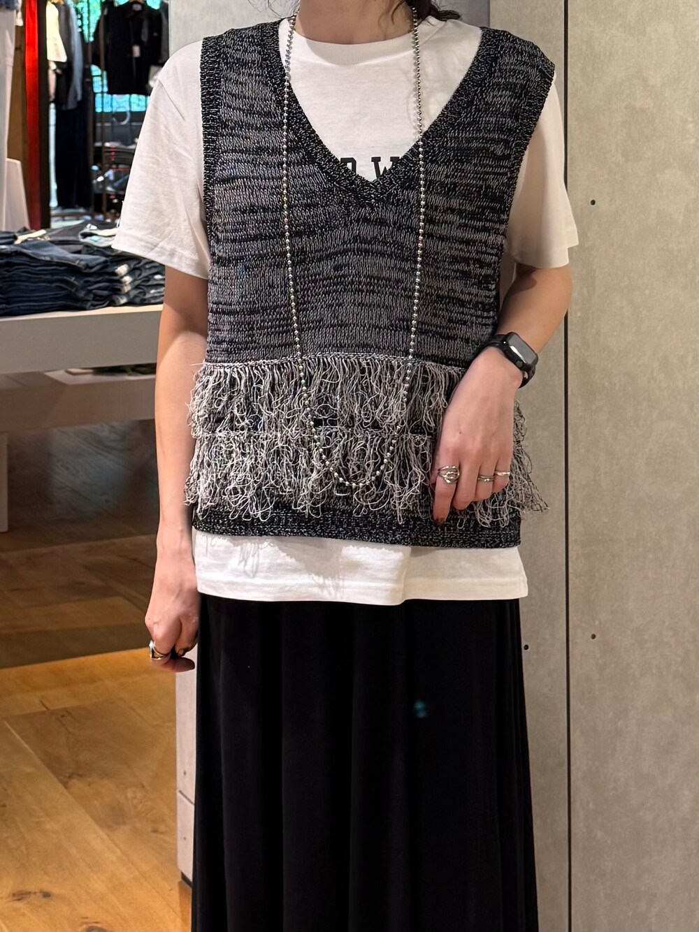 ブラック系のスカート、ブラック系のベスト、ホワイト系のTシャツ/カットソーを着用したレディースの夏コーディネートの7枚目の写真